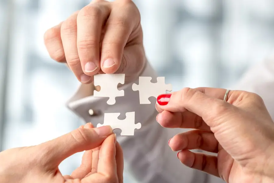 3 People Holding Puzzle Pieces
